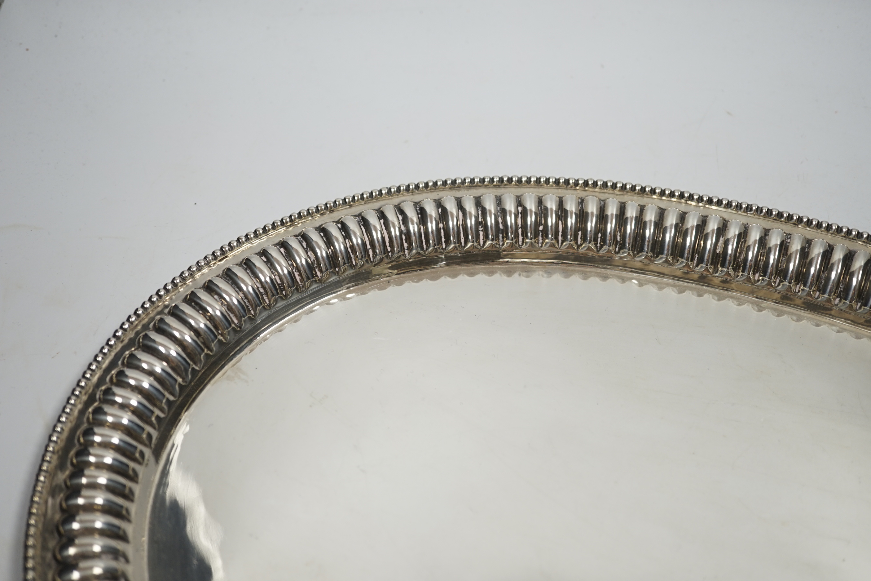 A Far Eastern white metal oval tray, with gadrooned and beaded rim, stamped silver, 45cm